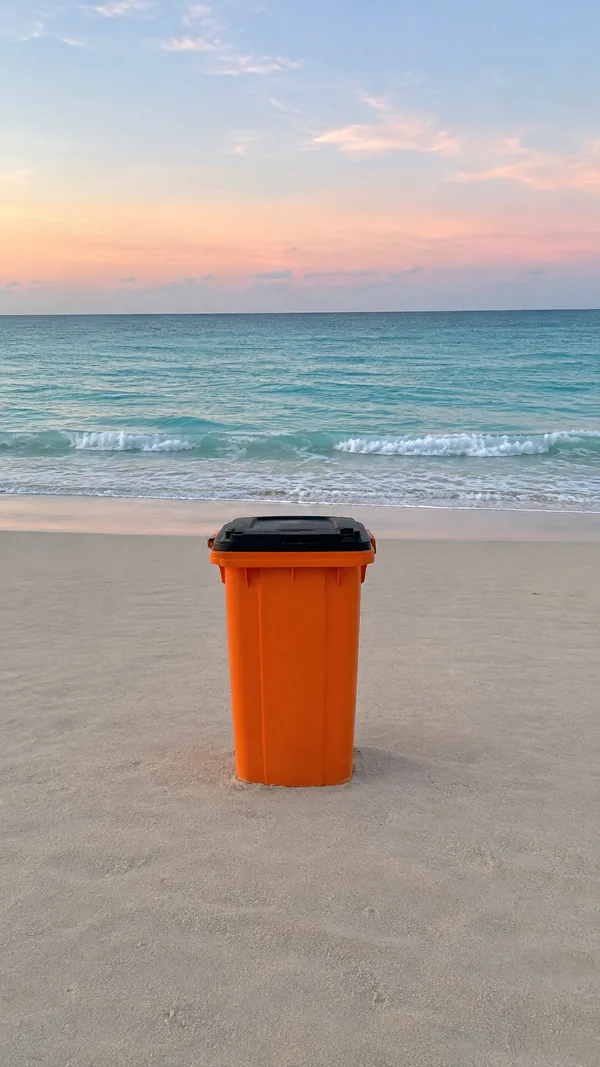 Before: an empty beach at dawn with an orange trash bin in the middle of the sand